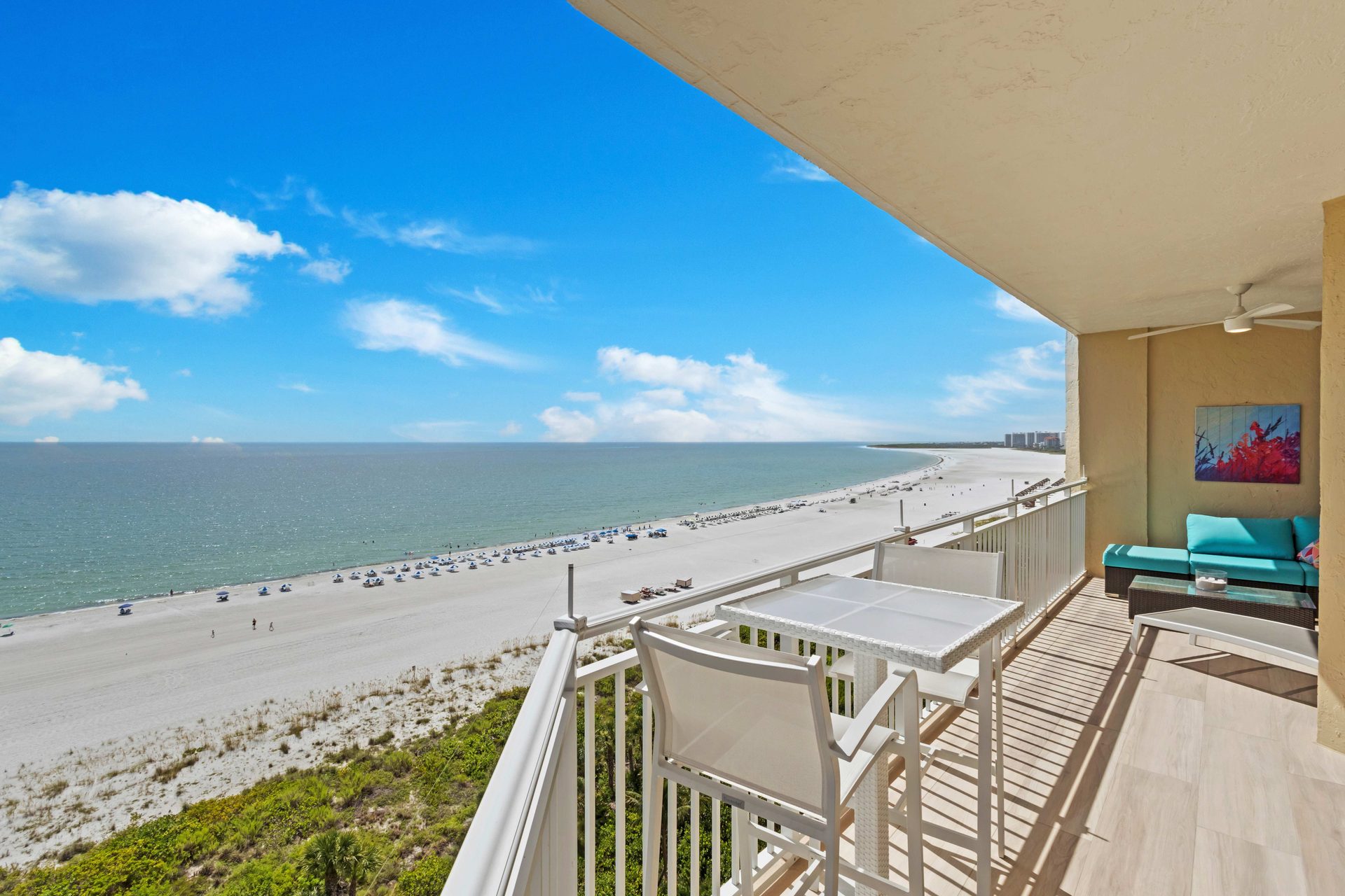 View of the Gulf and a long curving beach from a high beachfront balcony on Marco Island